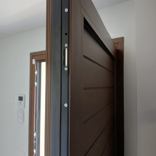 Puerta interior de aluminio con acabado imitación madera instalada en vivienda unifamiliar.