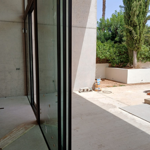 Detalle de perfiles de aluminio minimalista en cerramiento exterior de vivienda moderna, con acabado lacado.