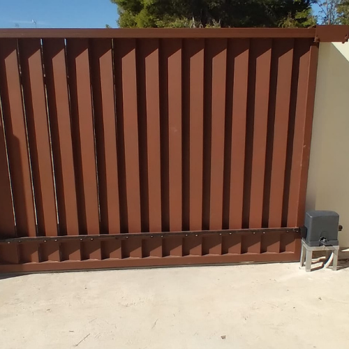 Valla metálica instalada y lacada en color, cerramiento finalizado con lamas verticales.
