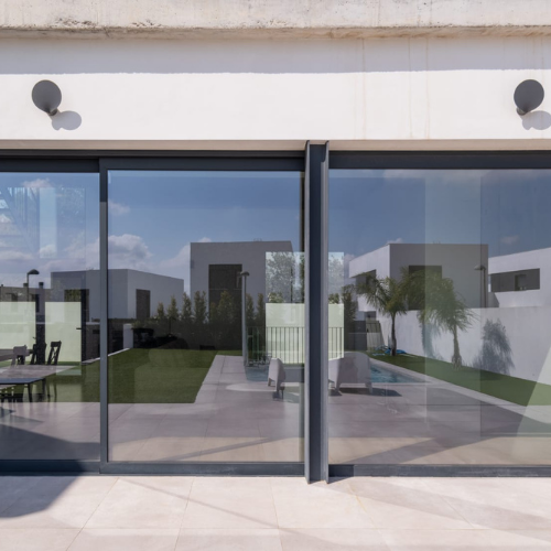 Carpintería de aluminio con sistema corredero y puerta batiente integrada en vivienda contemporánea.
