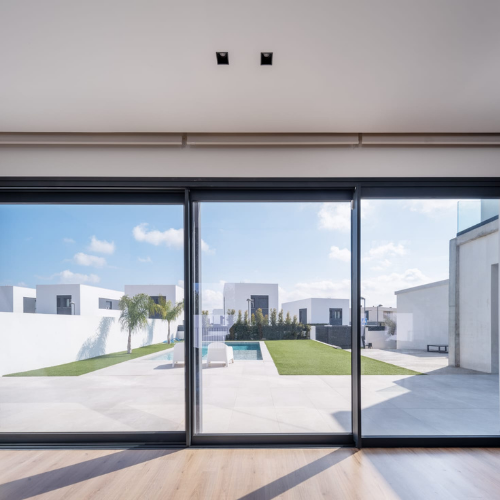 Cerramiento corredero de gran formato en aluminio antracita con perfiles esbeltos y vidrio laminado.