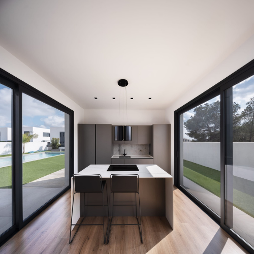 Ventanales panorámicos de aluminio gris antracita en comedor de vivienda moderna, con perfilería minimalista y vidrio de seguridad.