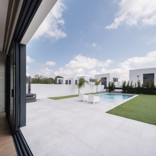 Puerta corredera de aluminio en color antracita con vidrio de seguridad, conectando salón y terraza en vivienda unifamiliar moderna.