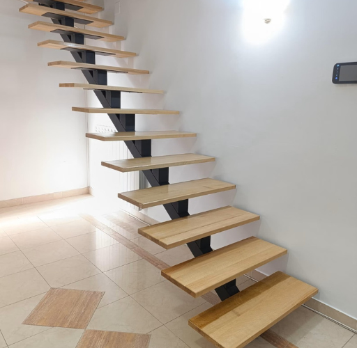 Detalle de escalera a medida con estructura metálica negra y peldaños de madera